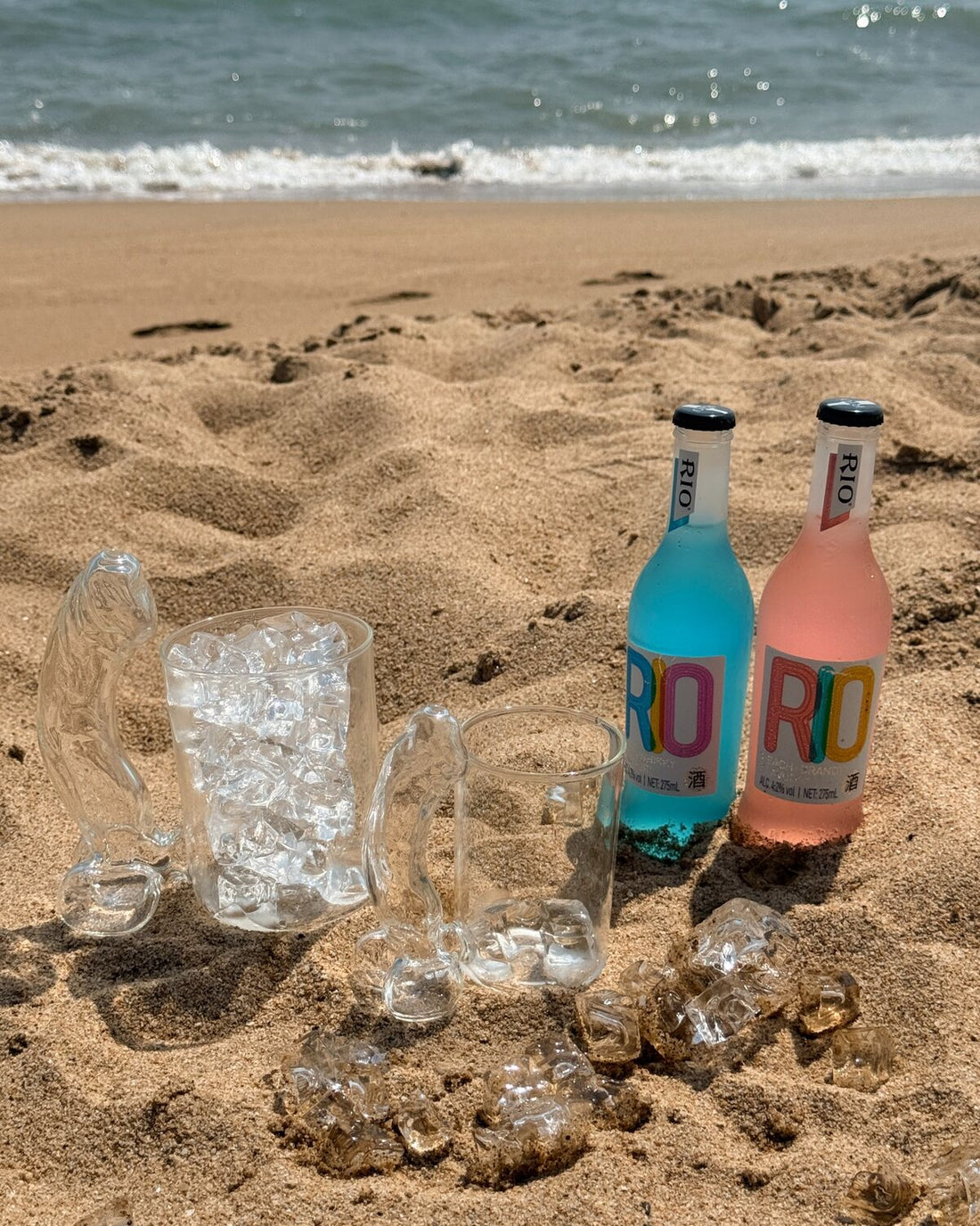 Clear novelty glass mug with colorful drinks on a sunny beach