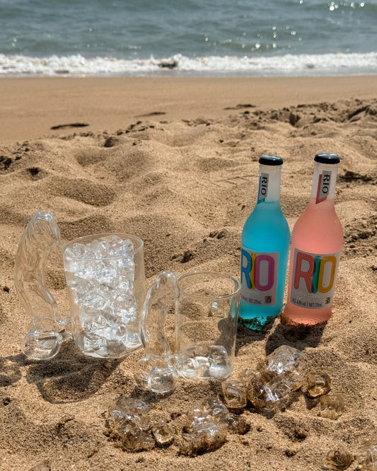 Clear novelty glass mug with colorful drinks on a sunny beach